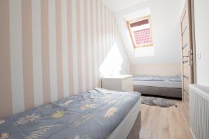 a small bedroom with a bed and striped walls at Piaskowe Domki in Grzybowo