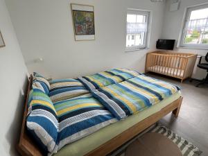 a bed with a striped comforter in a bedroom at Ferienwohnungen Christoph in Pfaffing