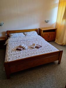 ein Schlafzimmer mit einem Bett mit zwei Hausschuhen darauf in der Unterkunft Jezero in Nova Varoš