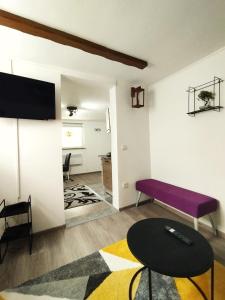 a living room with a purple bench and a table at Apartman Monroe in Sarajevo