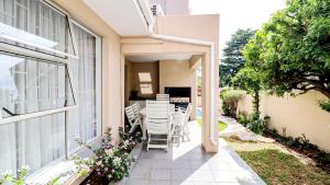un patio con sillas y una mesa en una casa en Luxurious Pvt Apartment ,Power backup, Jaccuzi & Pool en Sandton