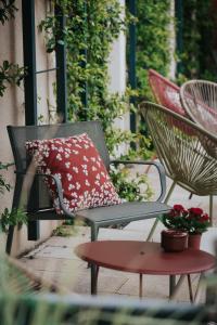 a chair with a pillow sitting on a patio at Hôtel Henry II Beaune Centre in Beaune