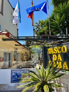 Hotel Vasco Da Gama في Sabaris: لافته امام مبنى عليه اعلام