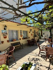 un patio al aire libre con sillas, mesas y toldo en Hotel Vasco Da Gama, en Sabaris