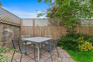 a table and chairs in front of a fence at Pebble Corner with Free Parking By My Getaways in Worthing