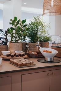 a counter with a bunch of potted plants and food at Hôtel Henry II Beaune Centre in Beaune