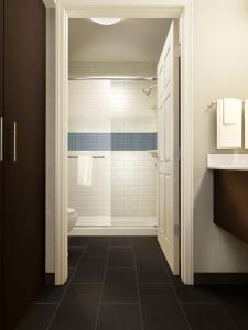 a bathroom with a shower and a toilet and a sink at Staybridge Suites Dearborn, an IHG Hotel in Dearborn