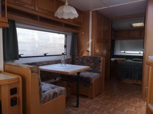 ein Wohnzimmer mit einem Tisch und einer Couch in einem Wohnwagen in der Unterkunft Maszoperia Sun4hel Kite & Wind & Surf in Jastarnia