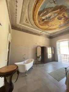 a bathroom with a tub and a painting on the ceiling at Apollo in Orosei +18 photos