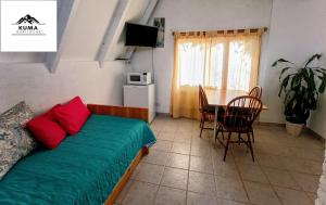 mały pokój z łóżkiem i stołem oraz tableablish w obiekcie Cabaña con Vista al Lago en Barrio Melipal - Bariloche w mieście Bariloche