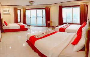 達沃市的住宿－The Humbertos Hotel，一间卧室配有两张红色和白色的床