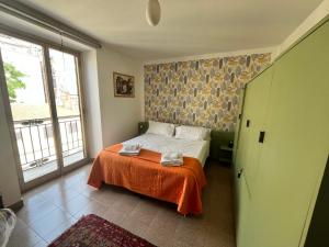 - une chambre avec un lit et une couverture orange dans l'établissement home.70 Carini, à Palerme