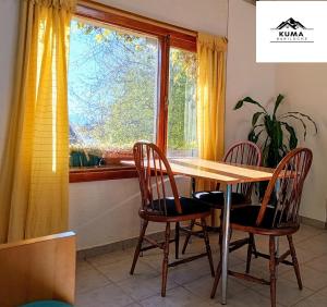 a dining room table with chairs and a window at Cabaña Kuma Bariloche Barrio Melipal in San Carlos de Bariloche +7 photos