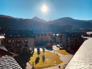 een stad met gebouwen en palmbomen en bergen bij B15 - Ático Los Copos - Villmor in Benasque