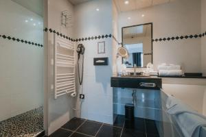 ein Bad mit einem Waschbecken und einem Spiegel in der Unterkunft Hôtel Henry II Beaune Centre in Beaune