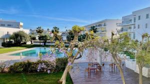 a deck with tables and chairs next to a swimming pool at Casa Maria Vera in Lagos