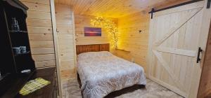 1 dormitorio con cama y puerta de granero en Loza house adirondack screened-in porch unit lake front en Plattsburgh