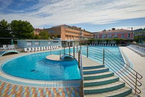 una piscina con scale accanto a un edificio di Hotel Delfin a Izola