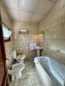 a bathroom with a tub and a sink and a toilet at Hotel Vasco Da Gama in Sabaris