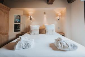 a bedroom with a white bed with towels on it at Hôtel Henry II Beaune Centre in Beaune