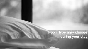una mano che tiene un cuscino con le parole del cambio della tipologia di camera durante il soggiorno di Hotel Vladimir a Budua