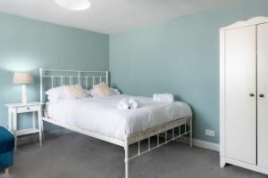 a blue bedroom with a bed with two stuffed animals on it at The Lodge Quaint Georgian Apartment, Wifi and Parking, near Bath in Box