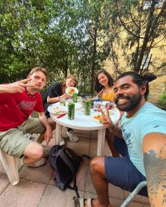 Eine Gruppe von Menschen, die an einem Tisch sitzen und Essen essen. in der Unterkunft Budapest Garden Hostel in Budapest