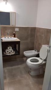 un baño con inodoro y lavabo en Allende Suite, en Villa Allende