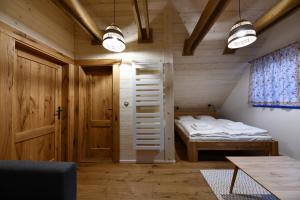 mały pokój z łóżkiem i drzwiami w obiekcie Tri borovice w Liptowskim Mikulaszu