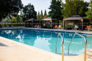 a swimming pool with chairs and a gazebo at Carowinds Camp Wilderness in Charlotte