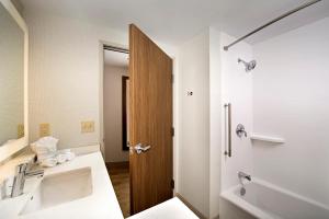 een badkamer met een wastafel en een bad bij Holiday Inn Express & Suites by IHG Altoona, an IHG Hotel in Altoona