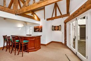 a kitchen with a wooden bar with stools at Finest Retreats - Low Green Cottage in Catterick Bridge