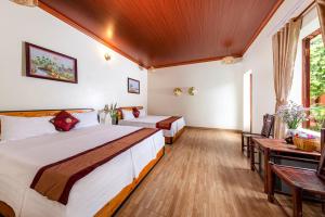 1 dormitorio con 2 camas y mesa en Trang An Family Homestay en Ninh Binh