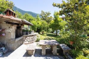 un banco de piedra sentado fuera de una casa en Appartement in Vesio mit Terrasse, Garten und Grill - b54556, en Tremosine Sul Garda