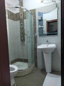 een badkamer met een douche, een wastafel en een toilet bij A's Hospitality in Ikeja
