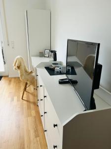 einen weißen Schreibtisch mit einem Spiegel und einem Stuhl in der Unterkunft Deluxe in Burladingen
