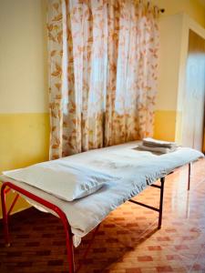 een bed in een kamer met een gordijn bij Daffodils Guest House Calangute in Calangute