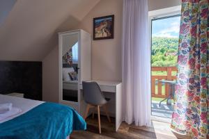 sypialnia z łóżkiem, biurkiem i oknem w obiekcie Dom Gościnny Wetlinn w Wetlinie