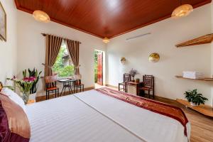 a bedroom with a large bed and a table at Trang An Family Homestay in Ninh Binh