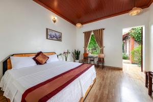 1 dormitorio con 1 cama, mesa y sillas en Trang An Family Homestay en Ninh Binh