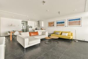 a living room with a couch and a table at Appartement met frontaal zeezicht in Bloemendaal in Bloemendaal
