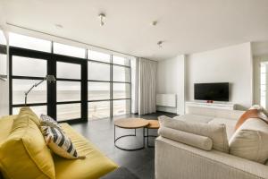 布羅門代爾的住宿－Appartement met zeezicht in Bloemendaal，带沙发和电视的客厅