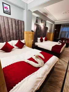 een hotelkamer met 2 bedden met rode kussens bij Hotel Avalanche in Shimla
