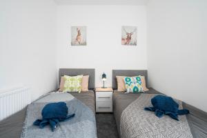 Duas camas num quarto com almofadas azuis em 3Bed-Close to Beamish Museum em Beamish