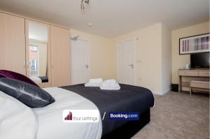 um quarto com uma cama grande e toalhas em Luxury 6 Bedroom Contractor House By Your Lettings Short Lets & Serviced Accommodation Peterborough With Free WiFi em Peterborough