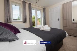 um quarto com uma cama grande e toalhas em Luxury 6 Bedroom Contractor House By Your Lettings Short Lets & Serviced Accommodation Peterborough With Free WiFi em Peterborough