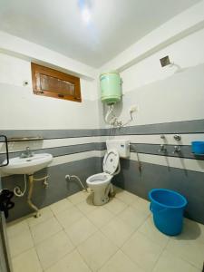 La salle de bains est pourvue de toilettes et d'un lavabo. dans l'établissement Madana Inn Manali, à Manali