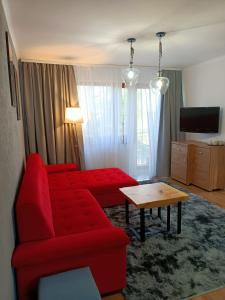 a living room with a red couch and a table at Pokoje Gościnne U Broni in Mielno