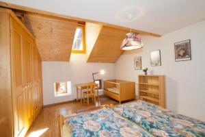 een slaapkamer met een bed, een bureau en een tafel bij Unterkunft il balcun tort - b48496 in Pontresina