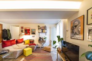a living room with a white couch and red pillows at Studio Garibaldi 7 in Verona